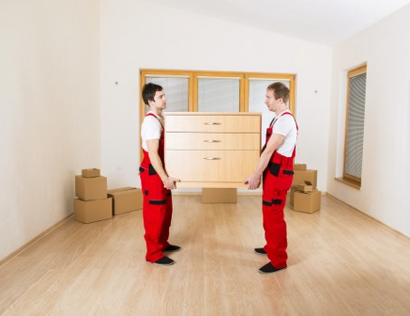 Trained movers carrying furniture carefully with gloves and teamwork